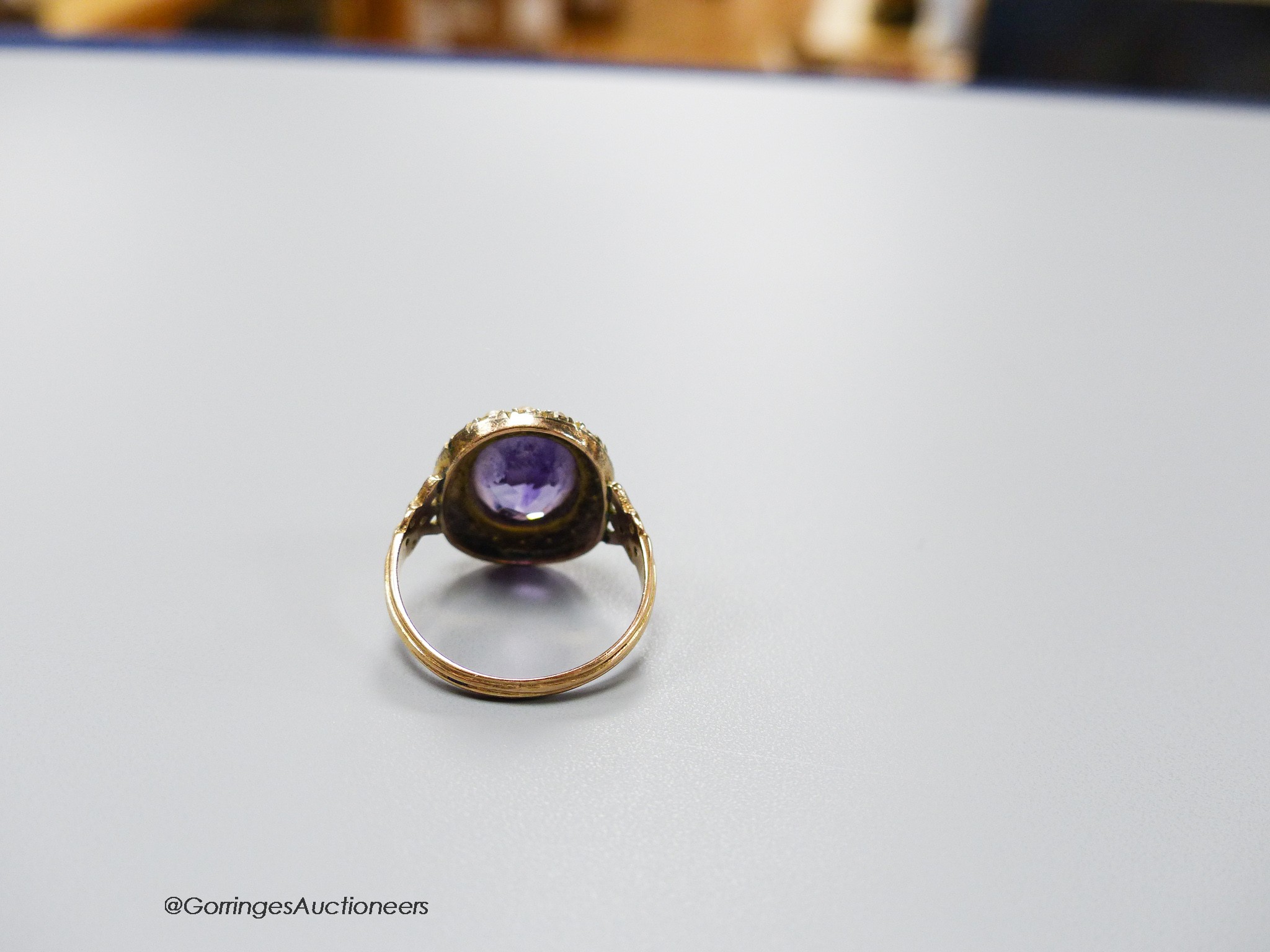 A 19th century yellow metal, amethyst and seed pearl set oval cluster dress ring, size N, gross 3.8 grams.